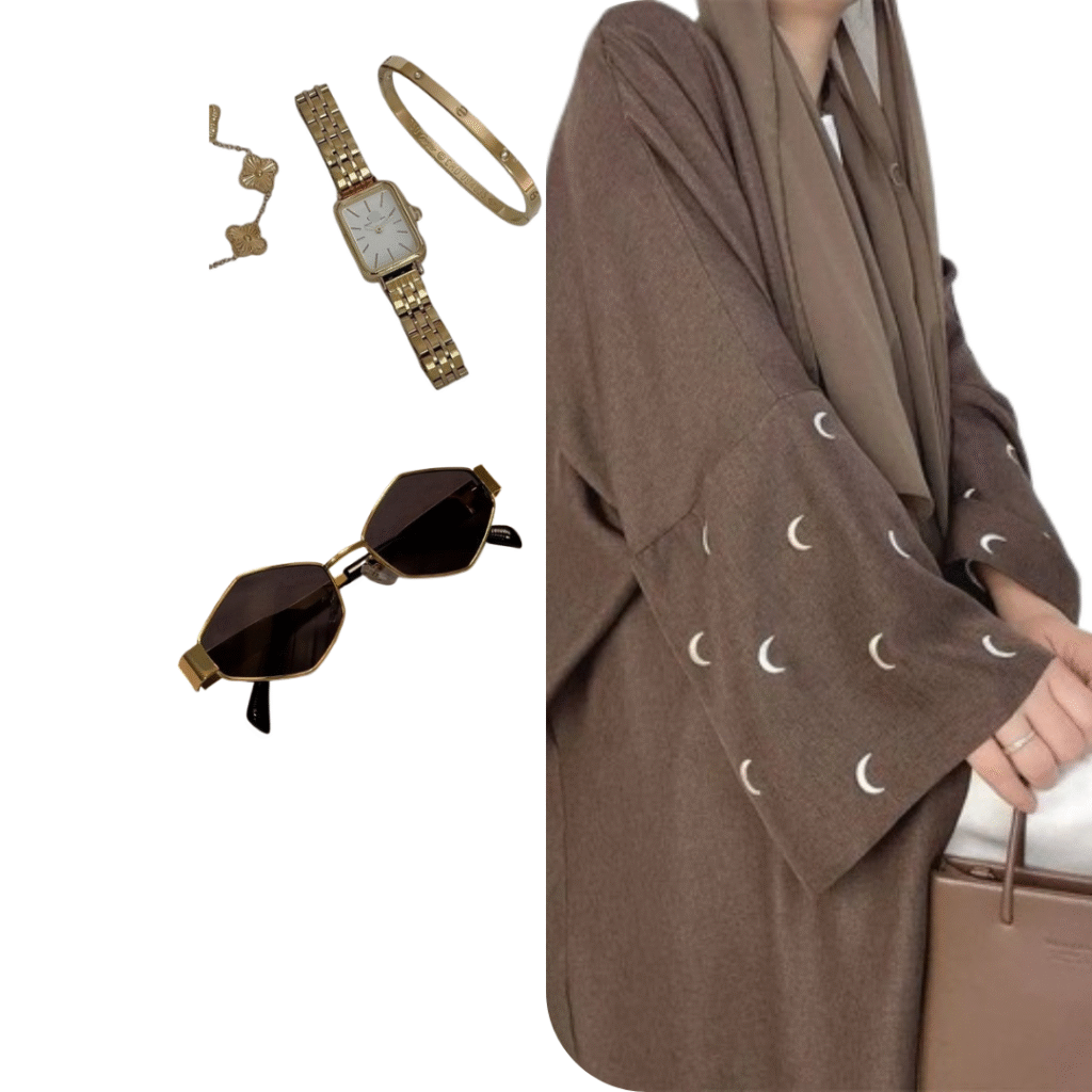 A brown abaya with crescent moon patterns, paired with gold jewelry including a watch, bracelet, and ring, along with hexagonal dark sunglasses.