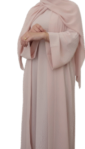 close-up of a model wearing a black abaya with wide, bell-shaped sleeves featuring elaborate pink floral and gold vine embroidery. The cuff has a scalloped, embroidered edge.