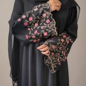 A two-panel studio image of a model wearing a dark brown, flowing abaya with white embroidered crescent moons on the sleeves, set against a smooth, warm beige background with soft shadows.